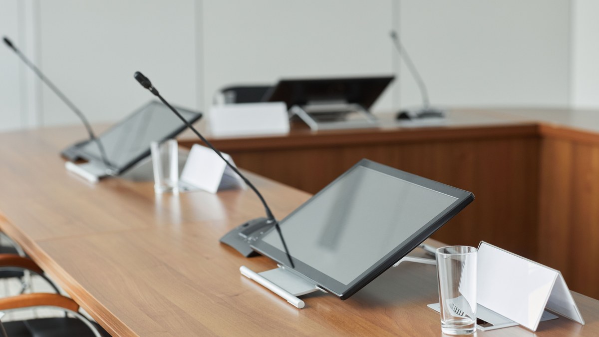 Boardroom AV systems — executive boardroom table with conference microphones and displays